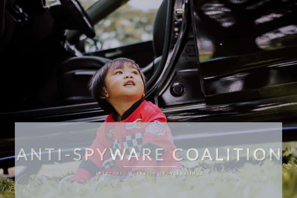 boy sitting on grass in front of parked car